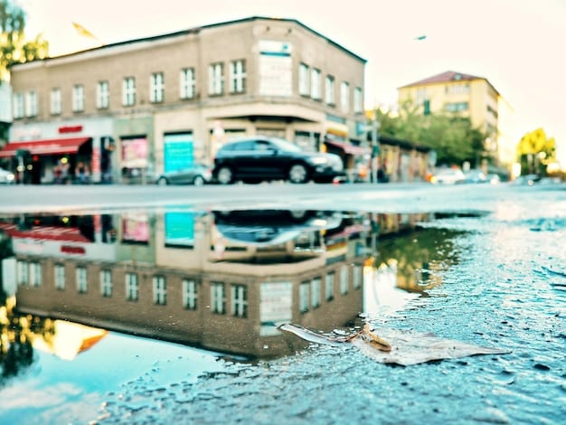 A photograph depicting a flooded street in a coastal town. Homes and businesses are partially submerged in water, and residents are wading through the water. The image illustrates the real-world impact of rising sea levels and coastal flooding.
