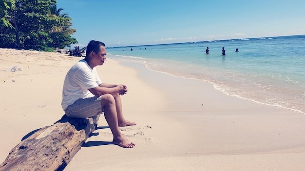 A person sitting on a beach, relaxed and using a laptop, with text overlay: